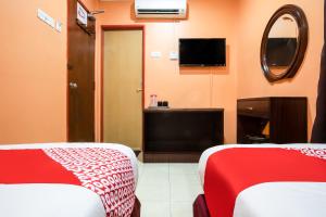 a hotel room with two beds and a tv at Ipoh Times Inn Hotel in Ipoh