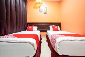two beds in a room with red and white sheets at Ipoh Times Inn Hotel in Ipoh