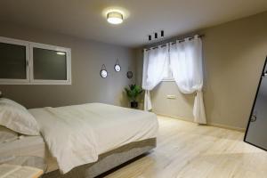 a bedroom with a white bed and a window at Louloudis Apartment in Limenas