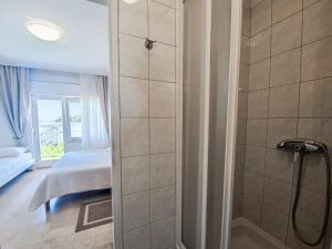 łazienka z prysznicem i łóżko w pokoju w obiekcie B&B villa IVONA w Baskiej Vodzie
