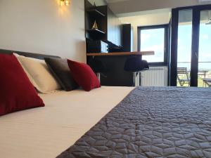 a bedroom with a large bed with red pillows at SUMMER HOME in Eforie Nord