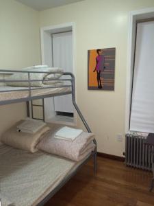 um quarto com 2 beliches e uma pintura na parede em Chrystie Street Apartments em Nova York