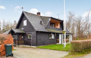 een zwart huis met een gambrel dak bij Amazing Home In Ljungby With Lake View in Bolmsö