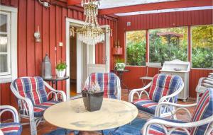 a patio with chairs and a table and a chandelier at Stunning Home In Ystad With Sauna, 3 Bedrooms And Wifi in Ystad