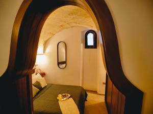 Habitación de hotel con cama y arco en La Casetta degli Ulivi, en Mesagne