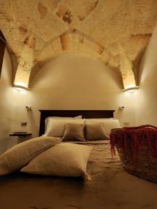 1 dormitorio con 1 cama grande y techo de piedra en La Casetta degli Ulivi, en Mesagne