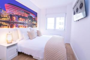 a white bedroom with a white bed and a window at Bilbao Henao Park de Bilbao Suites, en pleno centro con garaje directo in Bilbao