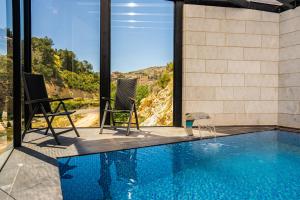 uma casa com uma piscina com duas cadeiras e vista em view hotel em Majdal Shams