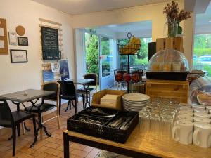 a restaurant with a counter with tables and chairs at Tourhôtel in Béthune