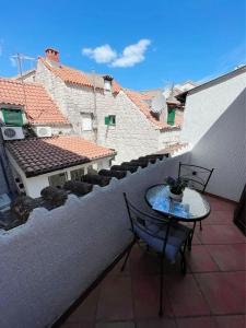 eine Terrasse mit einem Tisch und Stühlen auf dem Balkon in der Unterkunft House Ivancic in Trogir