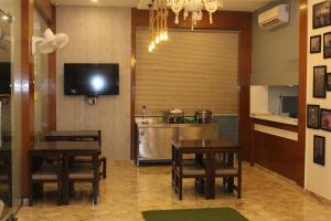 a dining room with two tables and a kitchen at Hotel Airside in Mumbai