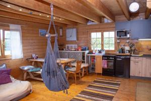 a kitchen with a hammock in a log cabin at Kuuseoksa Holiday Home in Viru-Nigula