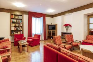 uma sala de estar com mobiliário vermelho e uma televisão em Albergo Belvedere em Fiera di Primiero