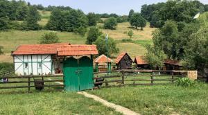 a small house in a field next to a fence at Apartman Bosanska Avlija-Muzej- in Visoko