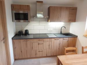 a kitchen with wooden cabinets and a sink at Apartma Mataj in Kobarid