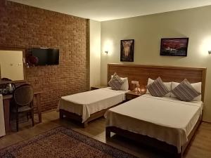 a hotel room with two beds and a television at Casa Callinos in Selcuk