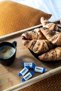 a tray with a plate of pastries and a cup of coffee at Maya's Flats & Resorts 52 - Aura 40 in Gdańsk