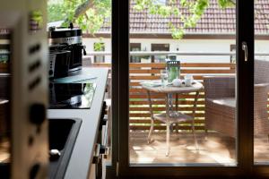 een balkon met een tafel en een keuken met een fornuis bij Domizil am Ostseewald - Seidelbast in Zingst