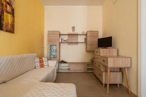 ein Wohnzimmer mit einem Sofa und einem TV in der Unterkunft Casa Maristella in Carloforte