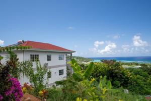 una casa blanca con el océano en el fondo en Creole Cottage Apartment en Anse Royale