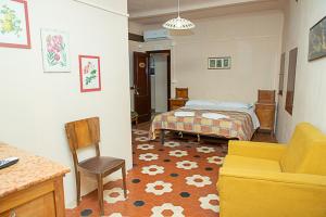 een slaapkamer met een bed, een stoel en een bank bij casa di Faustina (albergo diffuso) in Corinaldo