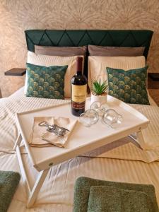 una mesa con una botella de vino y copas en una cama en Monte Home Center, en Novi Sad