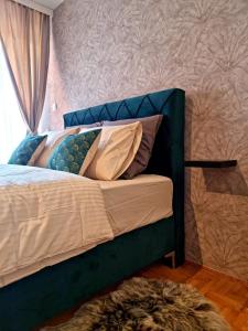 1 cama con cabecero azul y almohadas en Monte Home Center, en Novi Sad