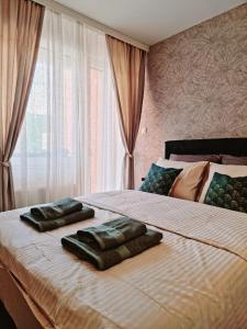 1 dormitorio con 2 toallas en una cama con ventana en Monte Home Center, en Novi Sad