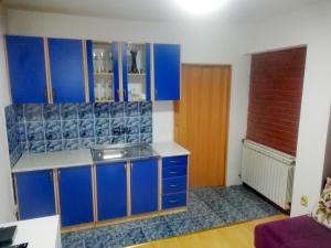 a kitchen with blue cabinets and a sink at Apartman Centar in Foča