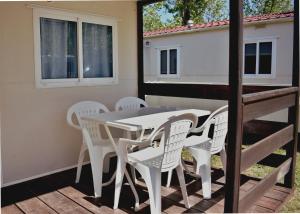 einen Tisch und Stühle auf der Terrasse eines winzigen Hauses in der Unterkunft Camping Bungalows Sol D´Or in Peñíscola