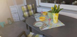 einen Tisch mit einem Tischtuch und einer Blumenvase in der Unterkunft Fewo Saur in Immenstaad am Bodensee