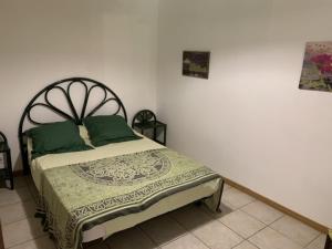 una camera da letto con un letto con cuscini verdi di A CANTINA a Ucciani