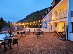 une terrasse avec des tables, des chaises et des lumières. dans l'établissement Willa Amelia, à Solina