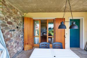 a patio with two blue chairs and a stone wall at ApartmentsGarda - Baia D'Argento Residence in Costermano