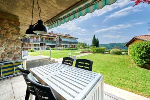 a white table and chairs on a patio at ApartmentsGarda - Baia D'Argento Residence in Costermano