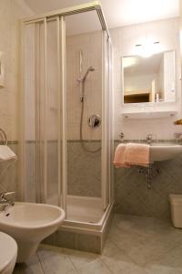 a bathroom with a shower and a sink at Pension Enzian in Badia