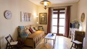 - un salon avec un canapé, une table et un réveil dans l'établissement Bonita vivienda en el corazón de Zaragoza, à Saragosse