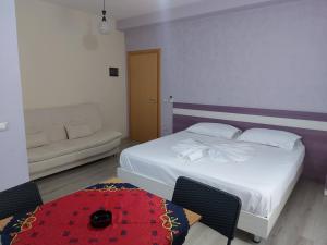 a bedroom with a bed and a couch and a table at Vila Green Relax in Vlorë
