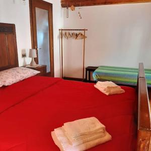 ein Schlafzimmer mit einem roten Bett mit Handtüchern darauf in der Unterkunft Casa Marconi Casa Vacanze in Cesara