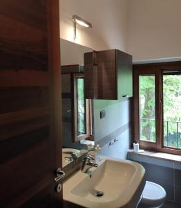 La salle de bains est pourvue d'un lavabo, de toilettes et de fenêtres. dans l'établissement Country House B&B Casa Bassa, à Piazza