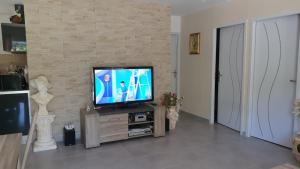 ein Wohnzimmer mit einem TV auf einem hölzernen Entertainment-Center in der Unterkunft Villa Entrechaux in Entrechaux