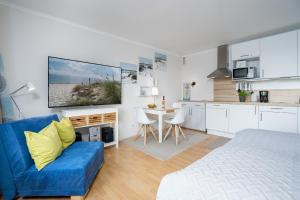 un soggiorno con divano blu e una cucina di Seetempel Wohnung 23 a Scharbeutz