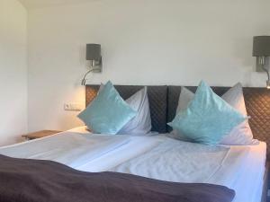 a bed with blue pillows on top of it at Appartement Haus Seerose in Reith im Alpbachtal