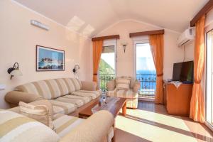 a living room with two couches and a television at Apartments Villa Sveti Nikola in Budva