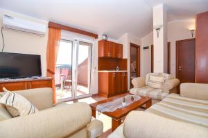 a living room with two couches and a television at Apartments Villa Sveti Nikola in Budva