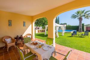 a dining room with a table and chairs on a patio at Casa Rural de Noa in La Puebla de Cazalla