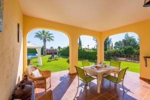 a dining room with a table and chairs on a patio at Casa Rural de Noa in La Puebla de Cazalla