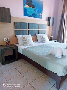 a bedroom with a large bed and a table at No Name Apartments in Laganas