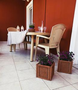 a dining room table and two chairs and some plants at No Name Apartments in Laganas