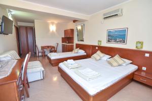 a hotel room with two beds and a desk at Apartments Villa Sveti Nikola in Budva
